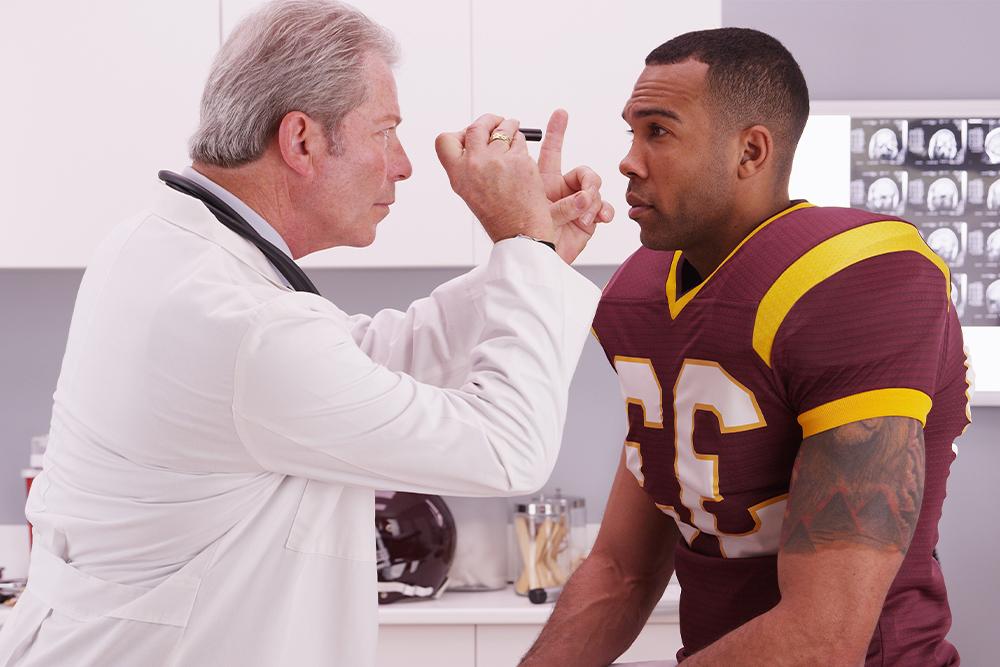 An image of a football player being examined by a physician