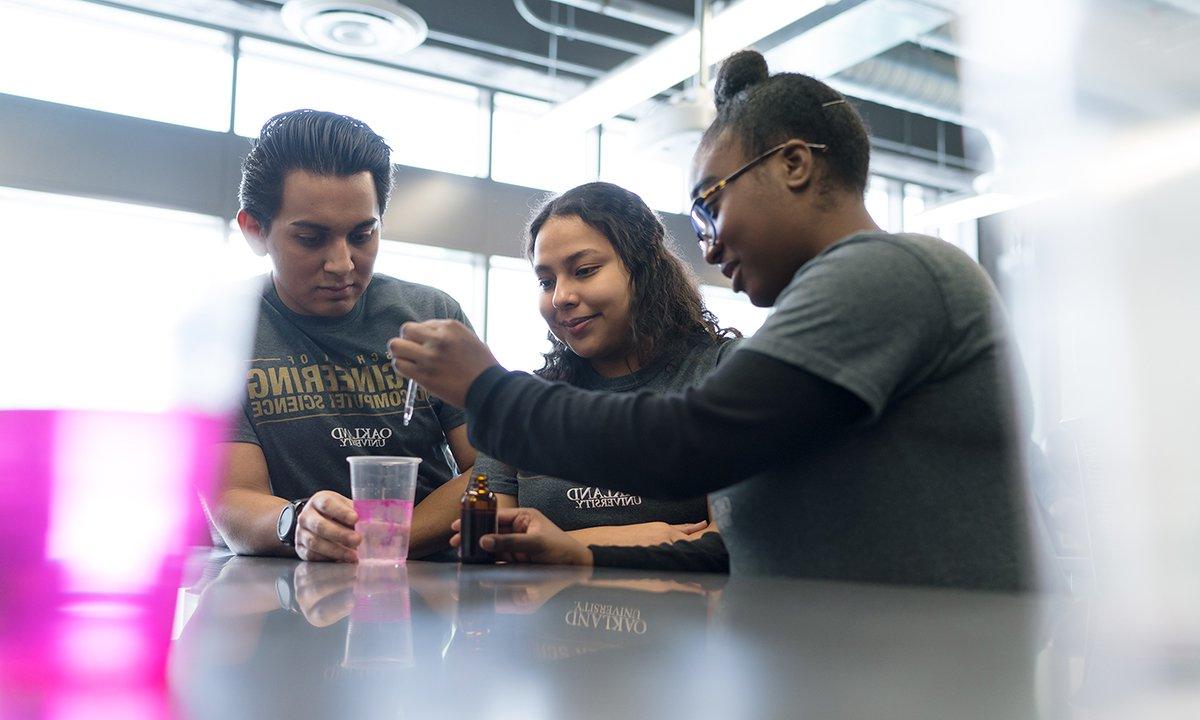 Three students doing a science experiment.