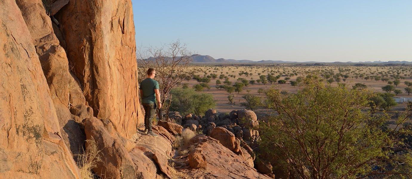 Man standing on cliff overlooking desert vista