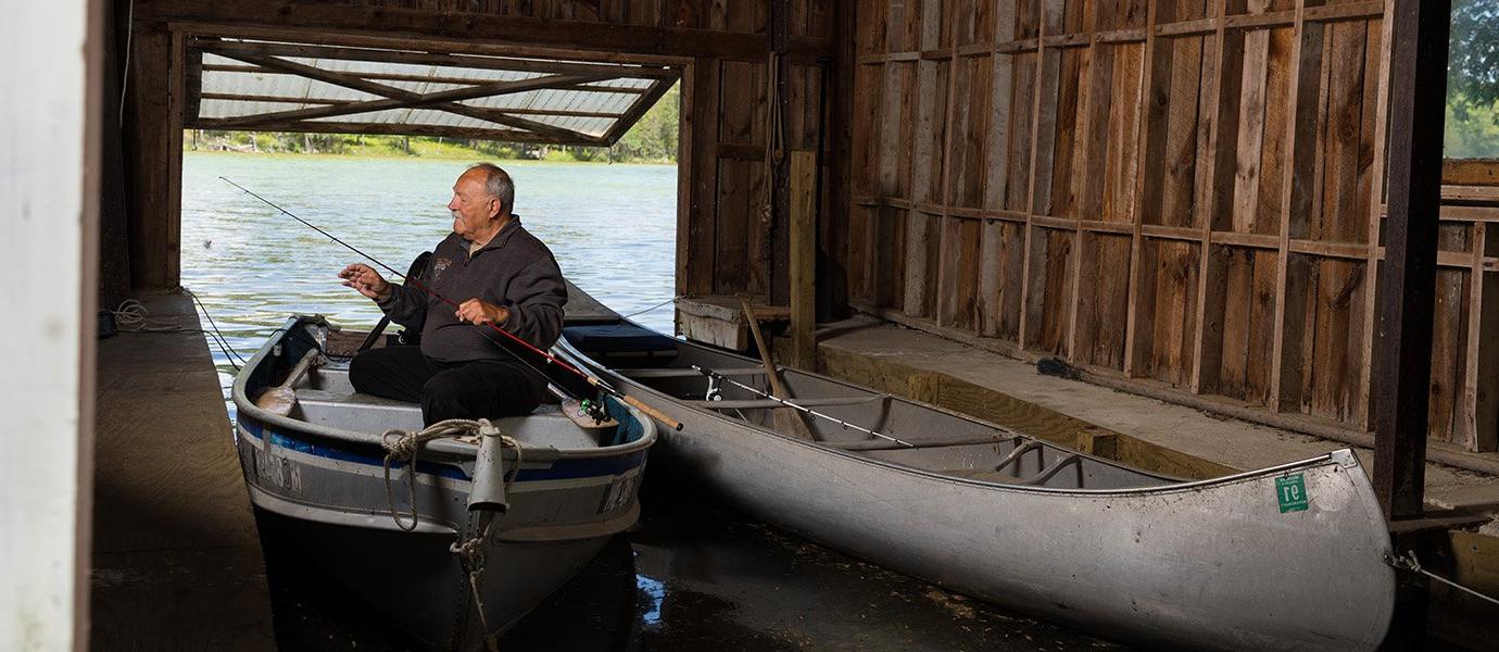 Man sitting in boat with fishing pole