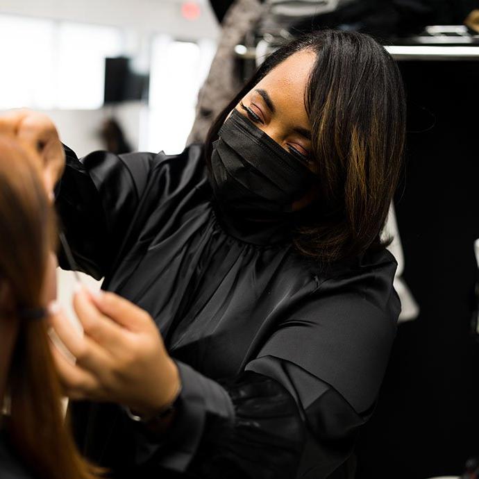 Woman with mask doing makeup on other woman