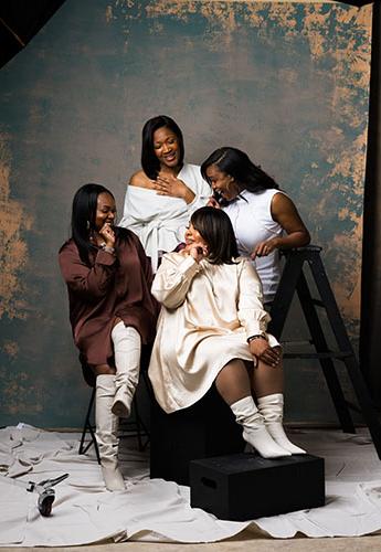 Four women sitting together laughing