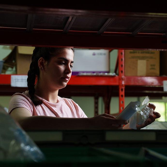 Woman looking through bins of medical equipment