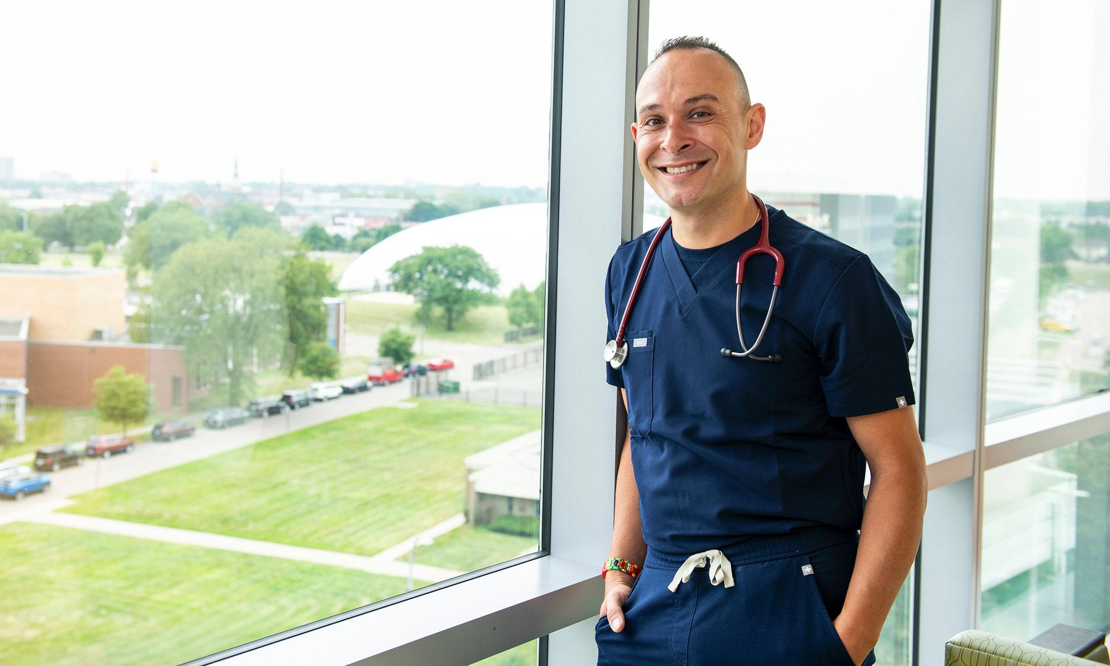 A person in scrubs next to a window