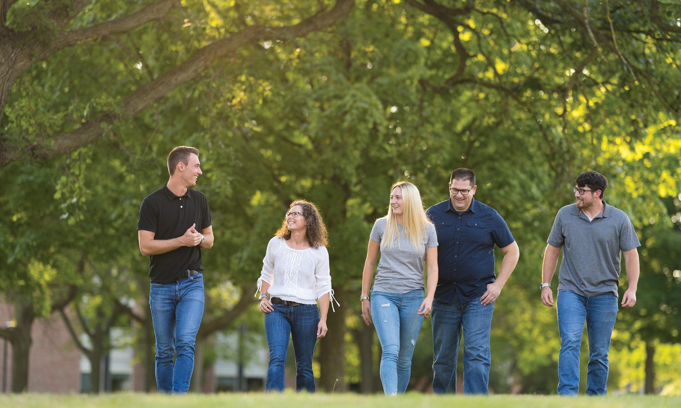 A group of five people walking outside.