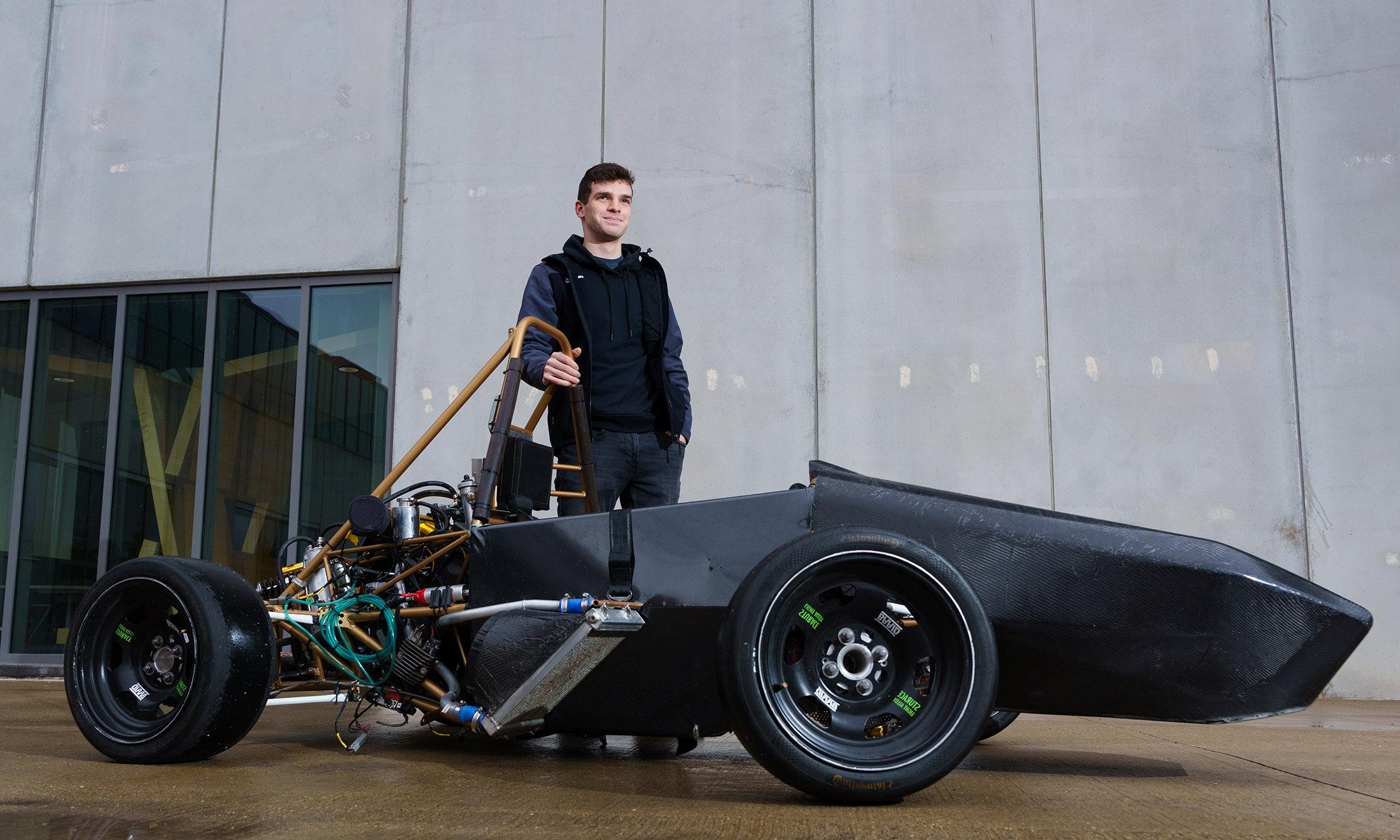 A man in front of an SAE car